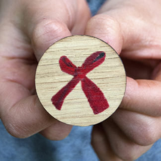 Image of pin badge featuring a red bow photo design